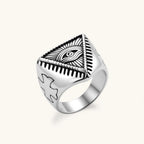 Silver stainless steel signet ring with engraved all-seeing eye in triangle, radiating lines, and cross motifs on the band.