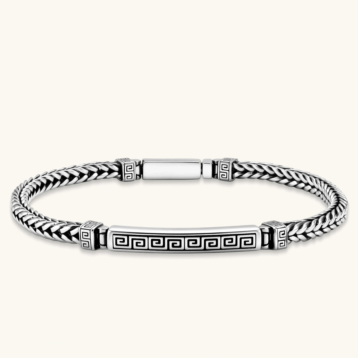 Silver stainless steel men's bracelet with braided foxtail chain, Greek key engraved bar, and decorative cube connectors.
