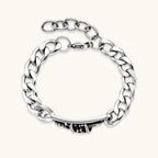 Silver 316L stainless steel Cuban chain bracelet with blackened skull and crown ID bar centerpiece, lobster clasp closure.