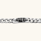 Silver 316L stainless steel Cuban chain bracelet with blackened skull and crown ID bar centerpiece, lobster clasp closure.