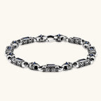 Front view of the stainless steel link bracelet with blue CZ stones and baroque scroll engravings.