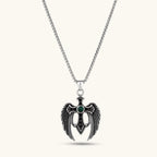 Front view of the silver stainless steel angel wing cross pendant with green CZ center stone and black crystals.
