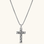 Silver stainless steel Celtic cross pendant with filigree vine pattern on a box chain, against a cream background.