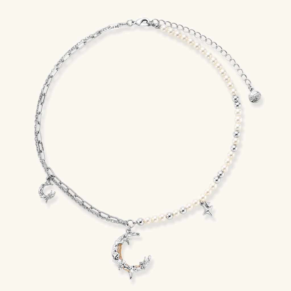 Alternate angle of the silver-toned crescent moon pendant with star accents and a single pearl bead on a fine chain.