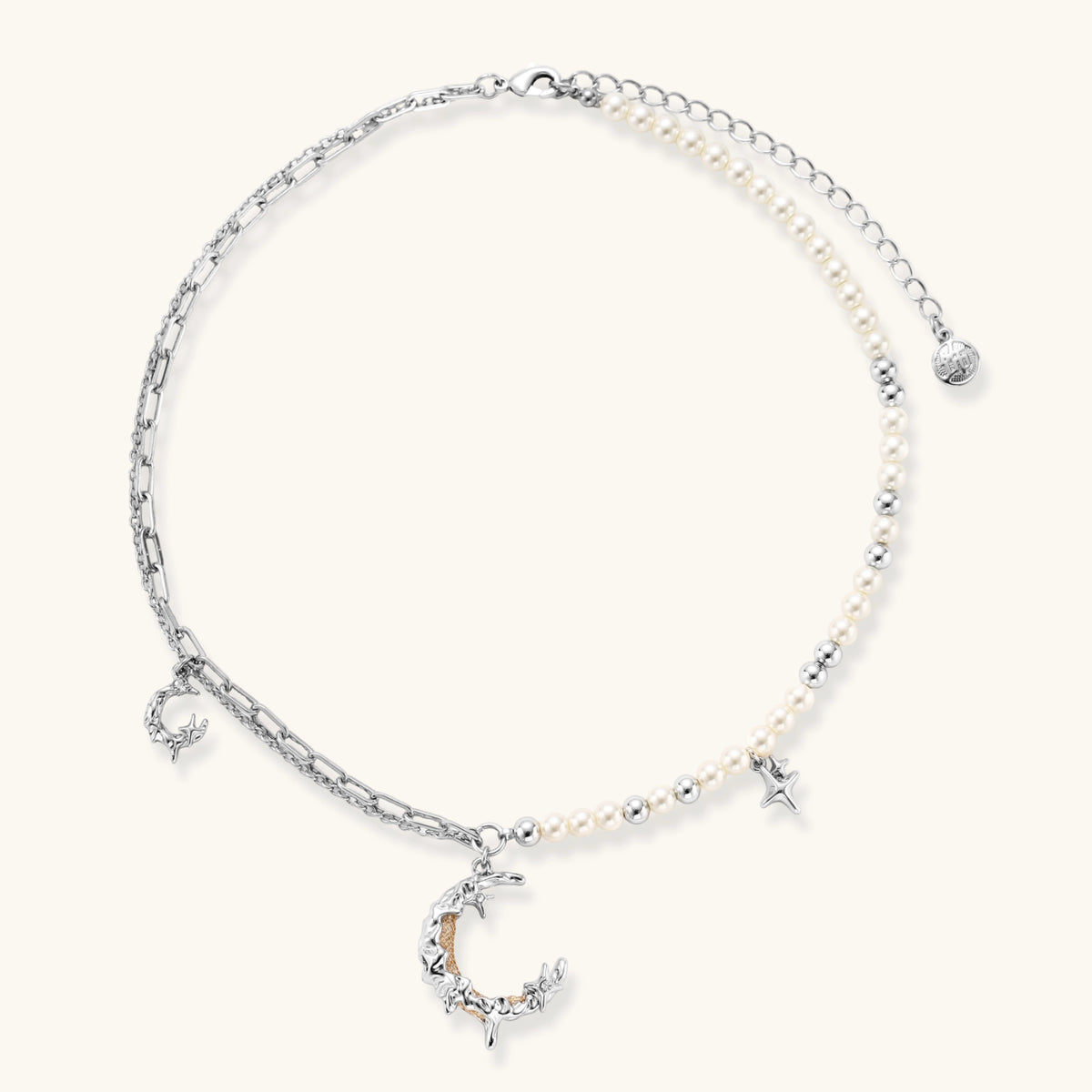 Alternate angle of the silver-toned crescent moon pendant with star accents and a single pearl bead on a fine chain.