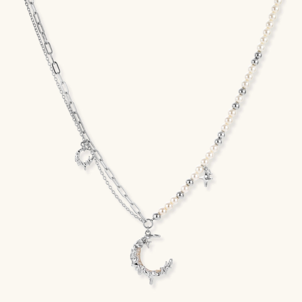 Front view of the silver-toned crescent moon pendant with star accents and a single pearl bead on a fine chain.