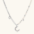 Front view of the silver-toned crescent moon pendant with star accents and a single pearl bead on a fine chain.