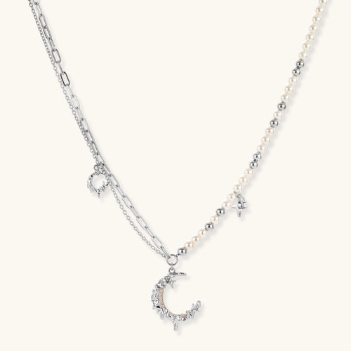 Front view of the silver-toned crescent moon pendant with star accents and a single pearl bead on a fine chain.