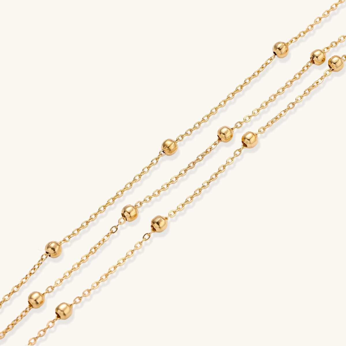 Alternate angle of the triple-strand gold-plated bracelet with clustered bead spheres.