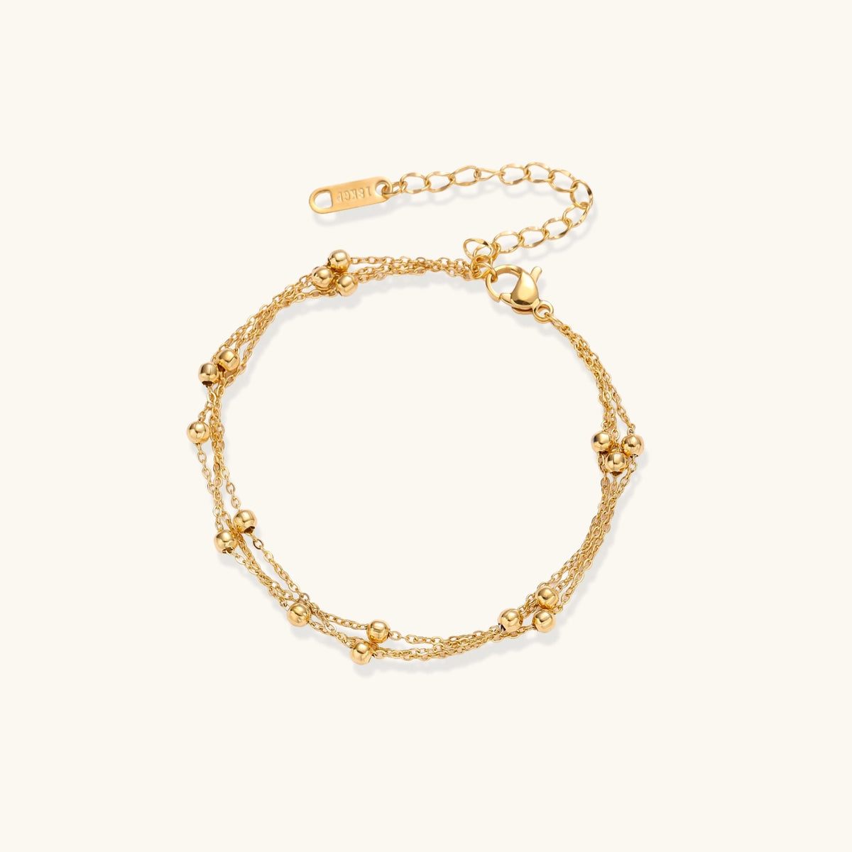 Front view of the triple-strand gold-plated bracelet with clustered bead spheres.