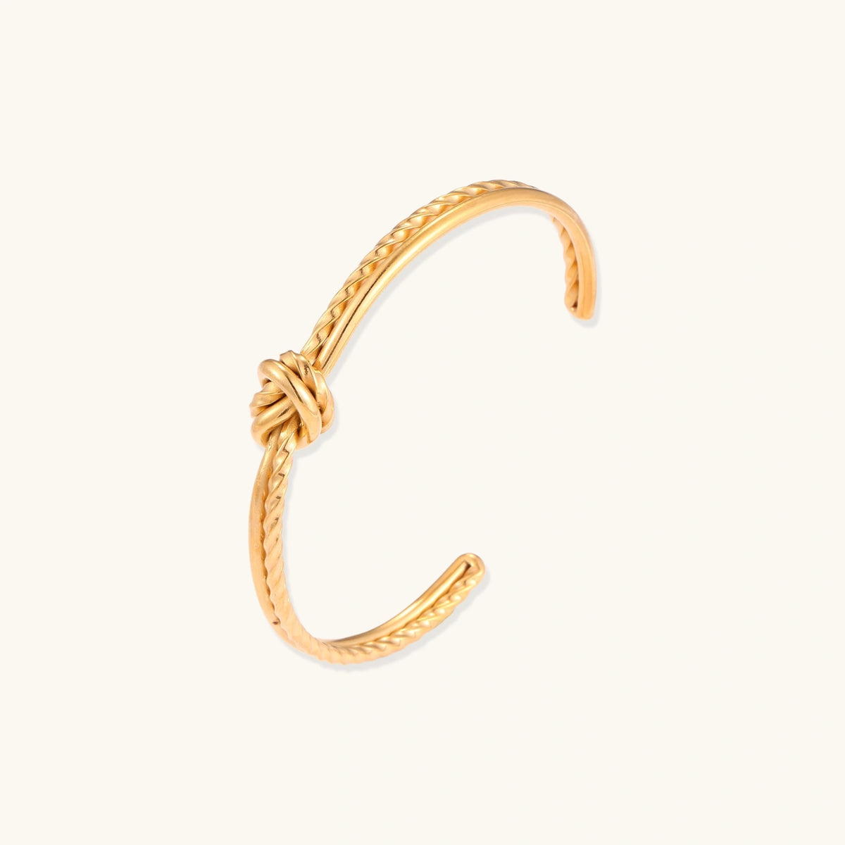 Alternate angle of the gold-plated cuff bracelet with twisted rope texture and a knot centerpiece.
