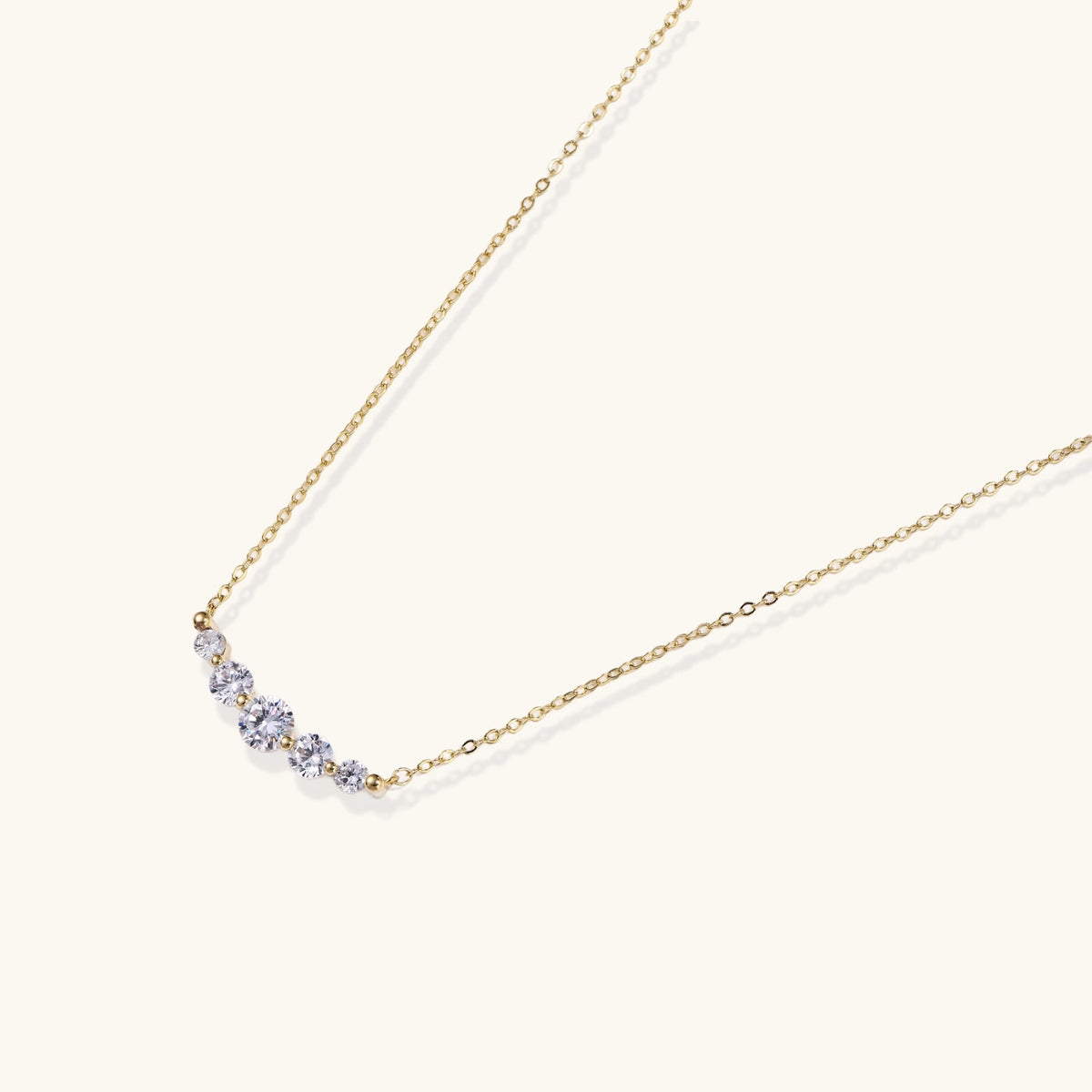 Alternate angle of the 14K gold-plated necklace with five curved zirconia stones on a fine chain.