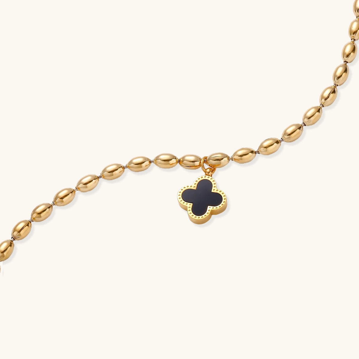 Additional angle of the 18K gold-plated beaded bracelet with a four-leaf clover charm in mother-of-pearl or black enamel.