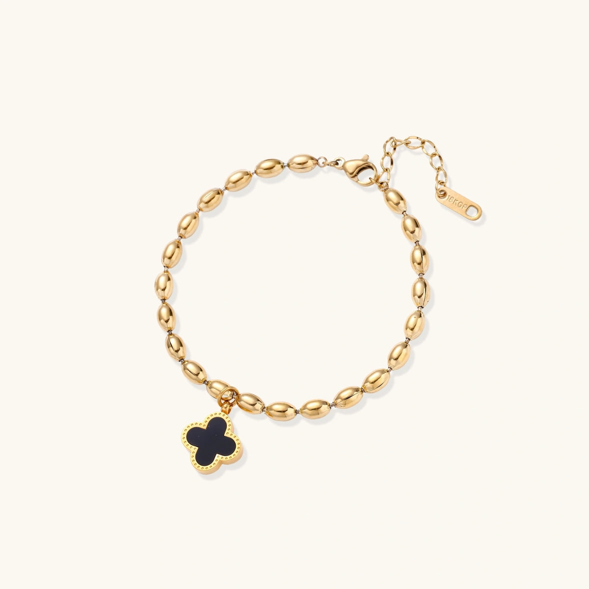Close-up of the 18K gold-plated beaded bracelet with a four-leaf clover charm in mother-of-pearl or black enamel.