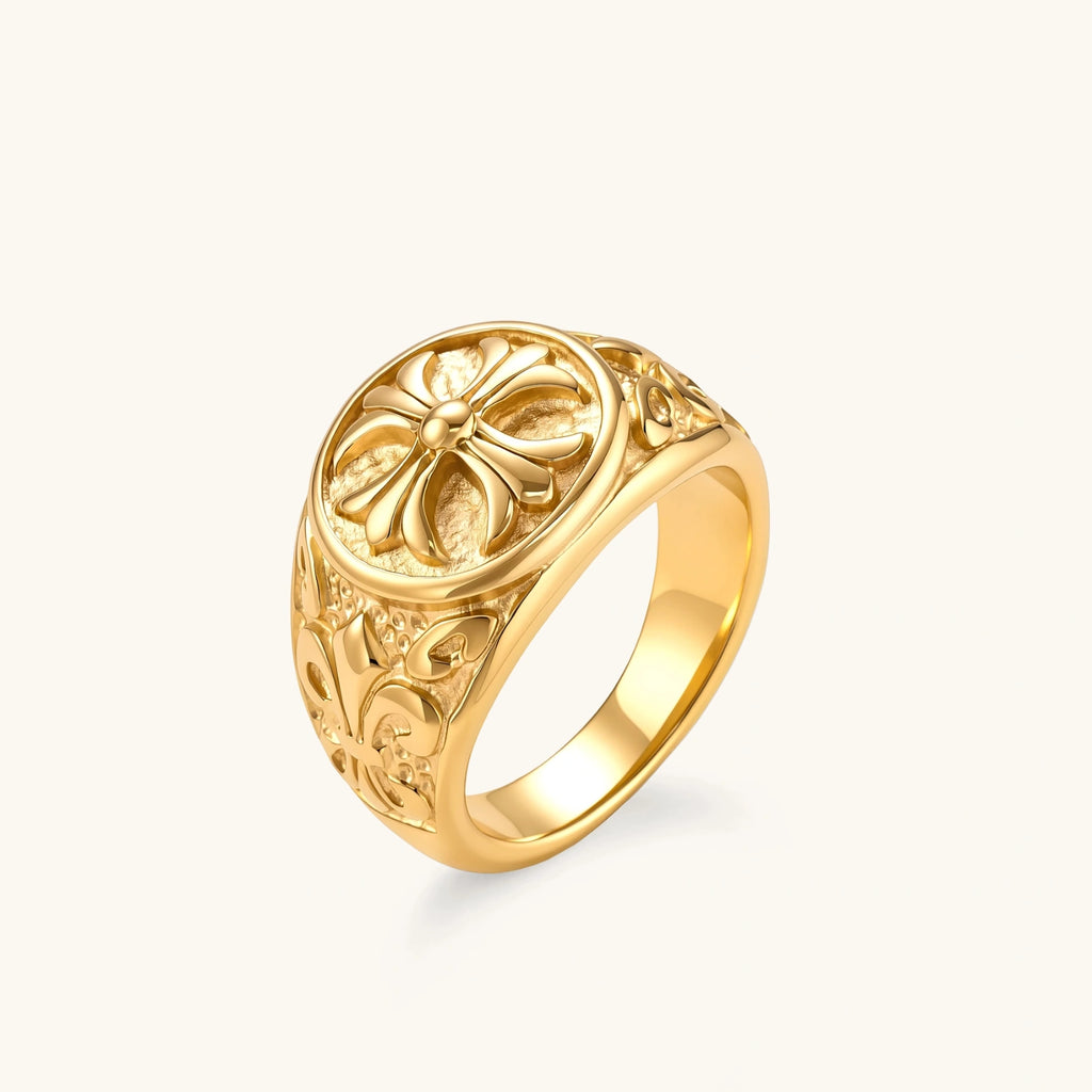Front view of the 18K gold-plated stainless steel signet ring with ornate cross face and filigree scroll band.