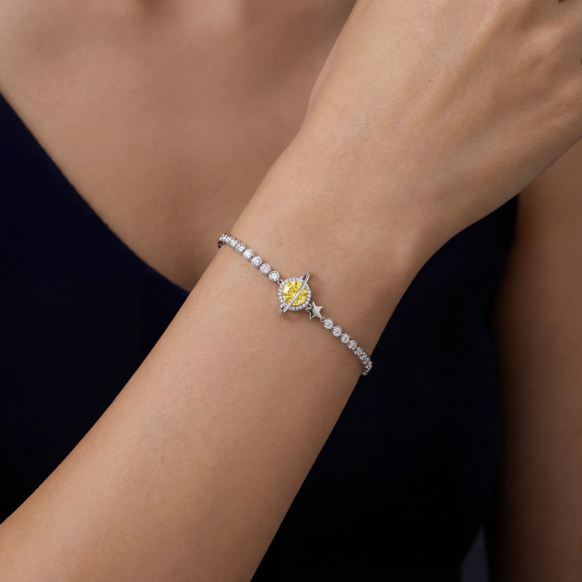 Detail view of the sterling silver bracelet with a yellow moissanite stone and a star charm.