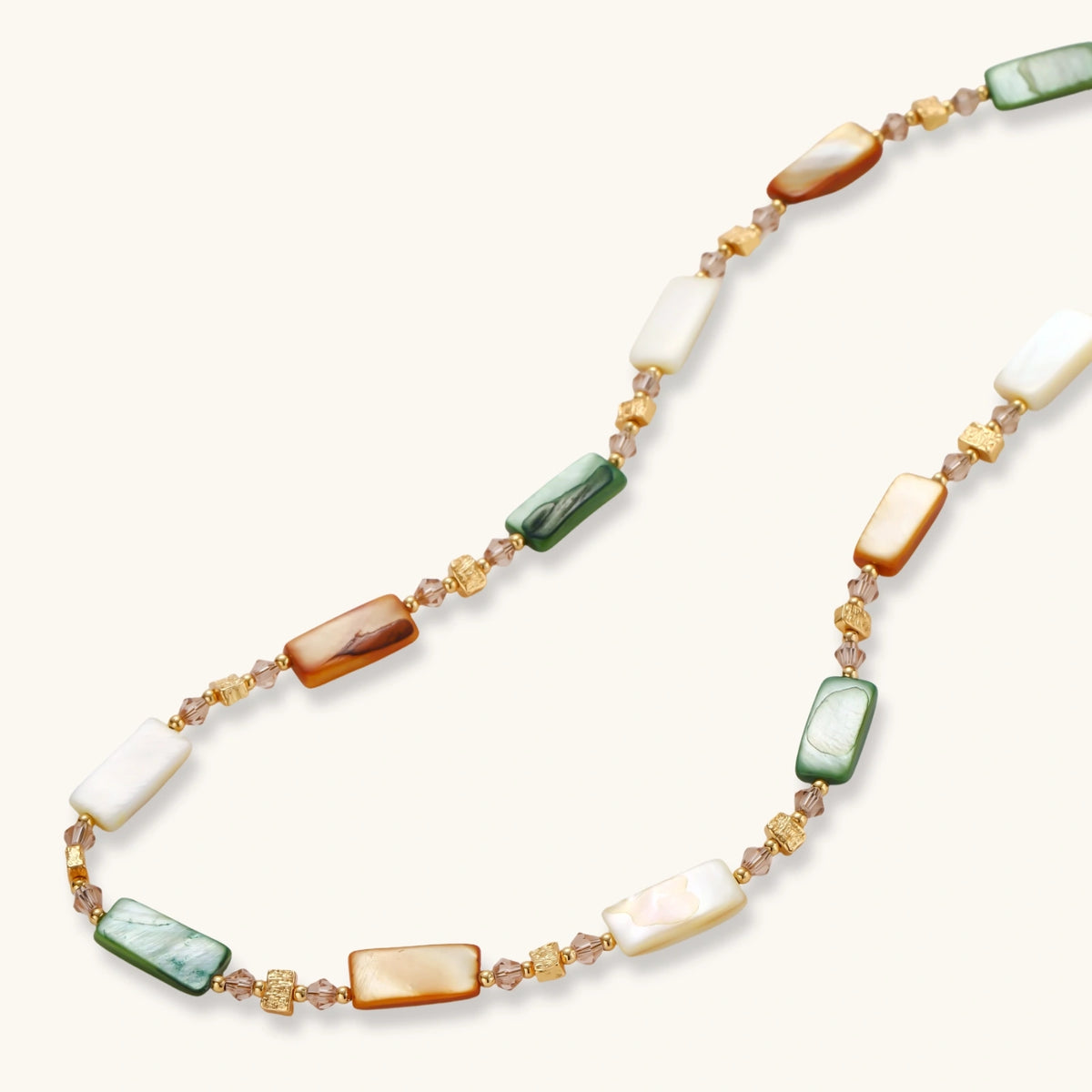 Alternate angle of the 18K gold-plated necklace with natural shell beads in green, amber, and cream tones.
