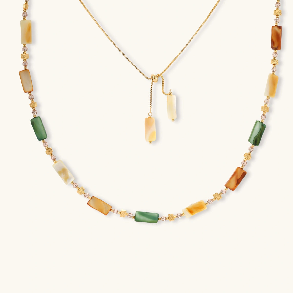 Front view of the 18K gold-plated necklace with natural shell beads in green, amber, and cream tones.
