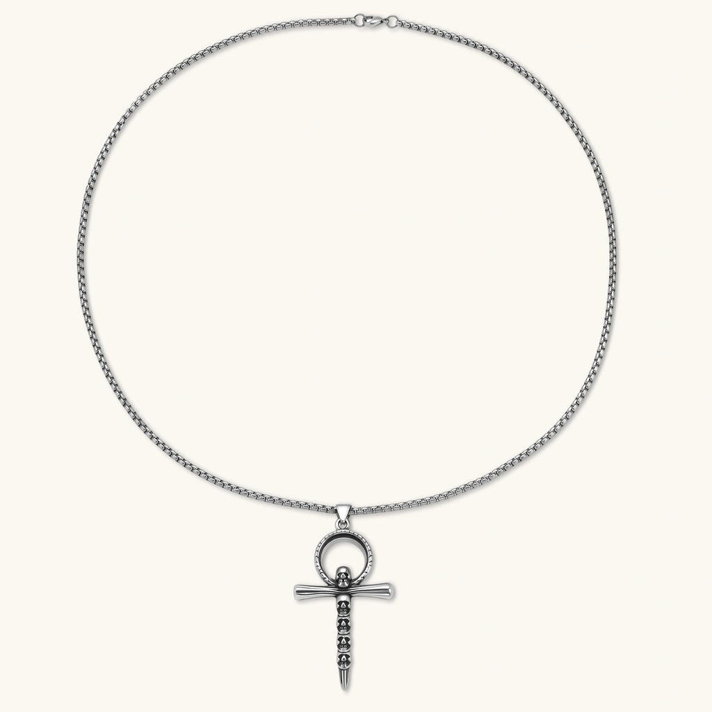 Alternate angle of the stainless steel ankh pendant with skull motifs on a box chain necklace.