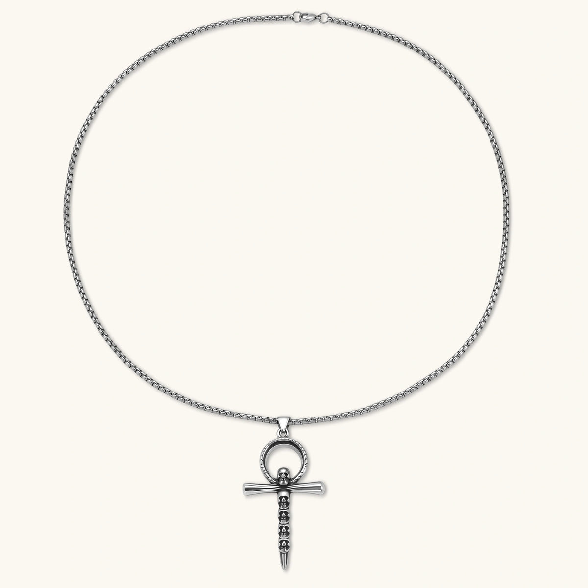 Alternate angle of the stainless steel ankh pendant with skull motifs on a box chain necklace.